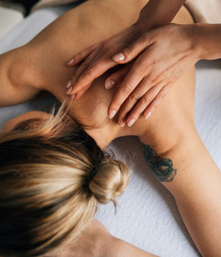 A woman receiving a relaxing shoulder massage from a therapist.